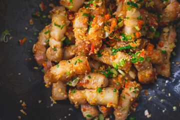 Stir fried pork belly slice with chili and salt in a black pan. Deliciousness of asian food. Thailand street food.