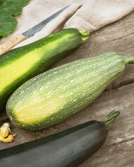 Eco friendly composition with organic, green zucchini with textile napkin on a wooden table. Locally grown vegetables and sustainable, climate friendly eating concept