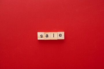 word SALE made of wooden letters on red background with copy space