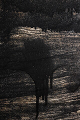 smudges of black paint on unpainted black metallic background with splashes of metallic sequins, repair concept