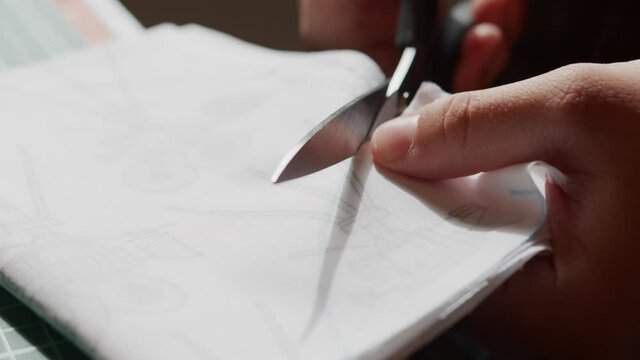 Closeup of woman hands holding scissors and cutting plaid fabric for sewing  clothes - a Royalty Free Stock Photo from Photocase