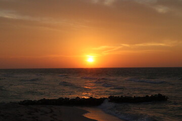 Atardecer en la playa puesta de sol en el mar con cielo naranja