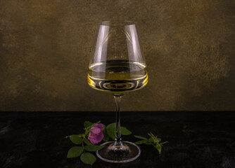 a glass of white wine with wild rose inflorescences
