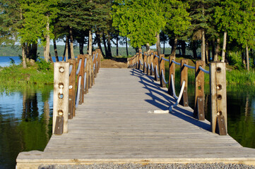 wooden bridge to treed island over water  