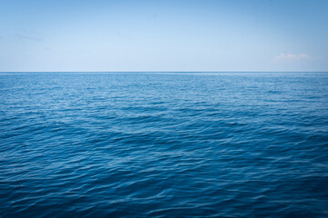 blue sea background.Marine sea surface reflecting the sun with coral reef under the water