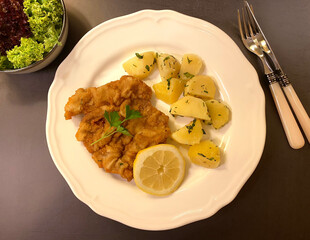 Austrian chicken schnitzel with parsley potatoes, lemon and leaf salad.