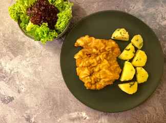 Austrian chicken schnitzel with parsley potatoes, lemon and leaf salad.