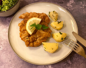 Austrian chicken schnitzel with parsley potatoes, lemon and leaf salad.