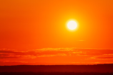 Fototapeta premium Background with bright orange light from the setting sun over the horizon. Sunset