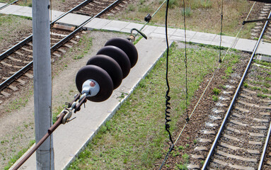 A railroad overhead power line component along a track with a rail electrification system that...
