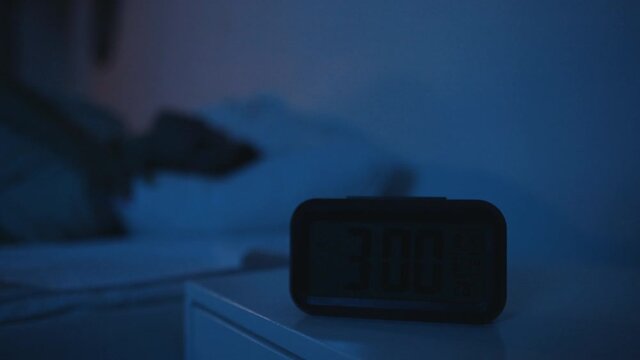 alarm clock by the bed at night close up