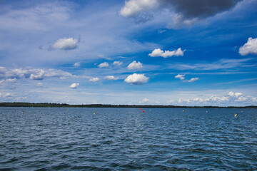 Obraz premium Weite Wasserfläche eines Sees mit bunten Markierungsbojen unter blauem Wolkenhimmel im Sommer, Cospudener See, Markkleeberg, Landkreis Leipzig, Sachsen, Deutschland