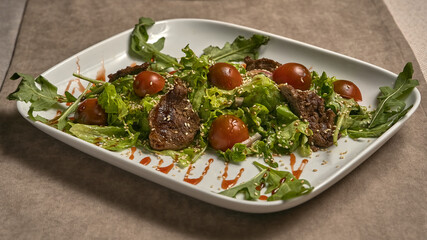 Fried meat with tomatoes and lettuce
