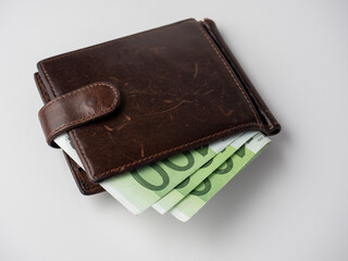 Close-up of a leather wallet full of euro bills on a white background. Business and Finance concept