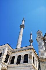 Fototapeta na wymiar View of two minarets and a mosque. High minarets against the blue sky. Old mosque in Istanbul.