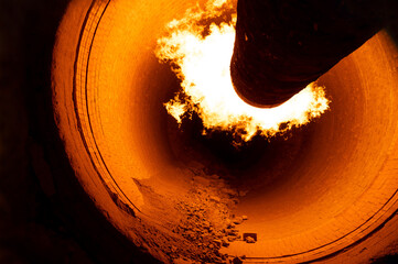 Close up of flame in rotary kiln during heating mode in cement plant - obrazy, fototapety, plakaty