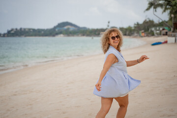 Fototapeta na wymiar Happy woman walking on the beach