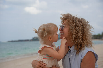 Happy girl playing with her grandmother on the beach