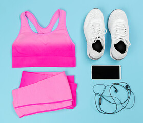 Flat lay on a blue background, sports equipment, sportswear undershirt, leggings, white sneakers, top view