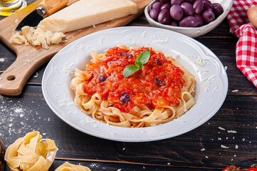 .Italian pasta dish with tomato sauce. Composition with ingredients for the preparation of the dish.