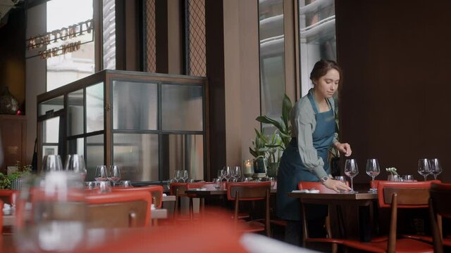 Slow motion of waitress setting table