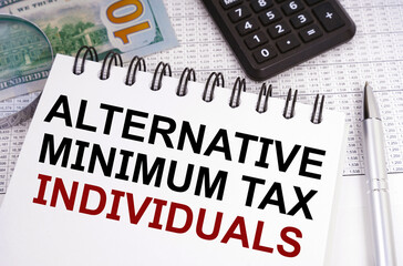 On the table there is money, a calculator and a notebook with the inscription - Alternative Minimum Tax - Individuals