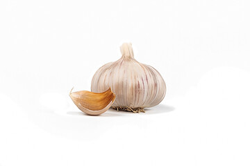 Studio lighting. A head of garlic and a small slice on a white background. Close-up.