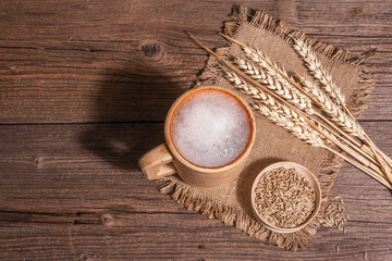 Beer and grain. Oktoberfest concept, wooden mugs on old table