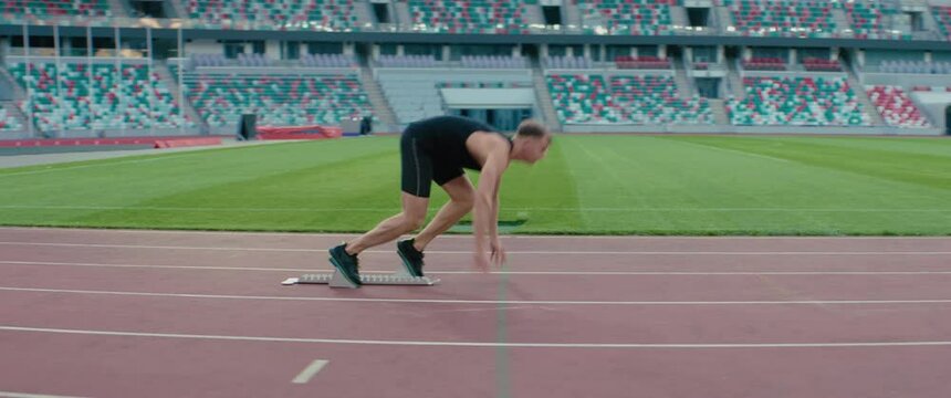 TRACKING Caucasian professional athlete practicing running on a large stadium. Shot with ARRI Alexa Mini with 2x anamorphic lens