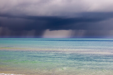 Heavy leaden clouds with rain over the blue sea. Typhoon over the Black Sea.