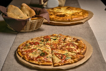 Ruddy pizza with red tomatoes on a wooden tray