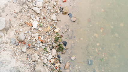 Top view of the river bank the border of water and sand, background.