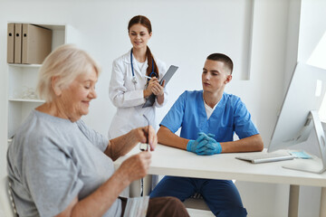 Obraz premium a nurse and a doctor communicating with an elderly woman patient in a medical office