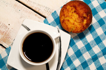 Taza de café en mesa de campo con panqué de naranja