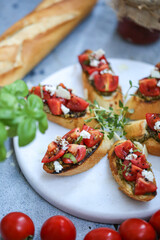 Bruschetta with tomatoes, basil and mozzarella on a marble board. Traditional Italian appetizer or snack, antipasto