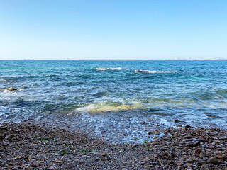 Stone coast of the blue sea with waves