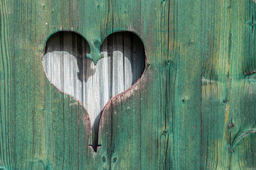 Holztür mit kleinem hineingeschnitzten Herz als liebevolles Detail