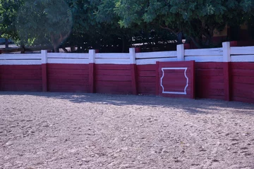 Fotobehang Stierenvechten Part of a bullring of a small bullfighting ring with a red barrier.  © Manuel