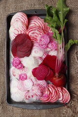 Various varieties of beets cut into thin slices. Chioggia beetroot, ordinary beetroot with green tops.