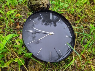 old and broken black clock in the forest in rainy time.