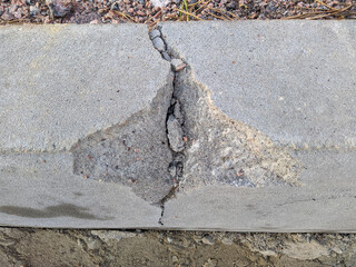 old and broken concrete curb in the daytime in summer. - obrazy, fototapety, plakaty