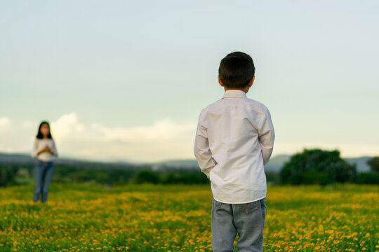Enfoque selectivo a ni&ntilde;o viendo a su hermana en un campo de flores