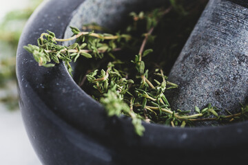 Bunch of fresh herbs in gray stone mortar with pestle - obrazy, fototapety, plakaty