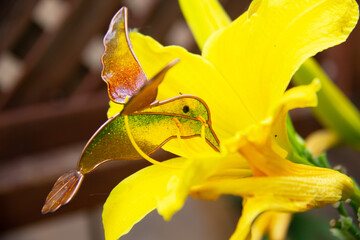 concept of hummingbird made of glass eating on flowers