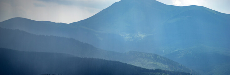 Sun rays and rain in the carpathian mountains in summer