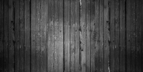 Old vertical wooden shabby dark gray background or texture, part of rustic fence or walls of house