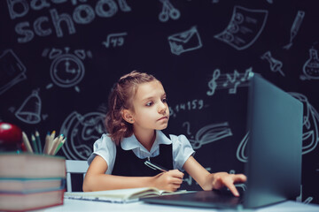Happy teen school student studying with laptop books doing online research homework assignment,...