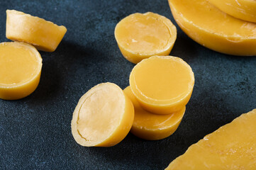 Blocks of beeswax for candle making. Raw beeswax. Handmade candle production - obrazy, fototapety, plakaty
