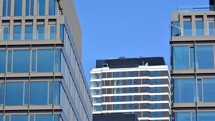 View of office building with glass wall under blue sky. Architecture details of business background.