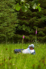A caucasian disability man resting in the bright green fresh forest.